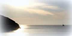 Coastal hill leaving the town of Korissa, Kea with motor yacht