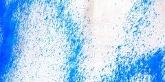Concrete wall with blue paint splatters