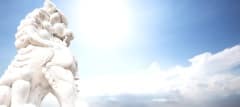 white stone lion sculpture in blue sunny sky