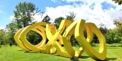 Yellow metal painted structure with blue sky and grass - landsca