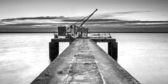 Ancient industrial pier, black and white pier with hoist