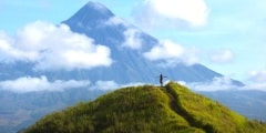 Hiker with backpack looks at the view on the Mayon volcano,Phili