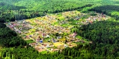 The cozy little village in the middle of the taiga forest. Airview